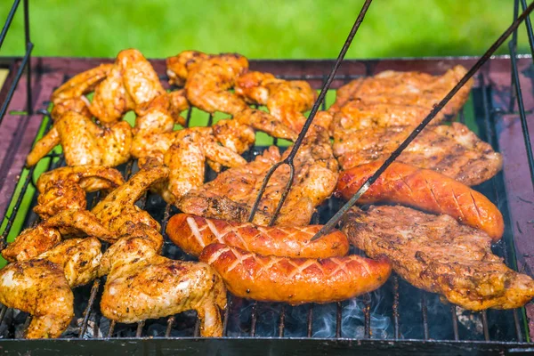 Grillfest i trädgården - urval av kött på flaming grill — Stockfoto