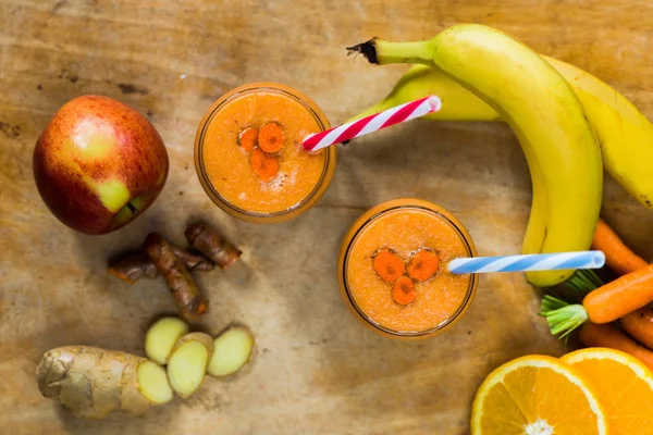 Batido con zanahoria, manzana, naranja, plátano, jengibre y tumérico — Foto de Stock