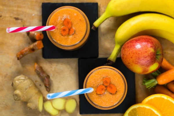 Смузи с морковью, яблоком, апельсином, бананом, имбирем и опухолью — стоковое фото