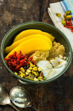 Mango, Antep fıstığı, goji meyveleri ve bal yoğurt ile Quinoa yulaf lapası