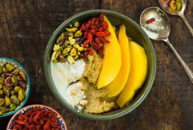 Mango, Antep fıstığı, goji meyveleri ve bal yoğurt ile Quinoa yulaf lapası