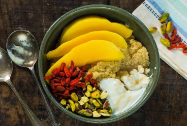 Mango, Antep fıstığı, goji meyveleri ve bal yoğurt ile Quinoa yulaf lapası