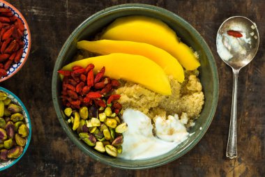Mango, Antep fıstığı, goji meyveleri ve bal yoğurt ile Quinoa yulaf lapası