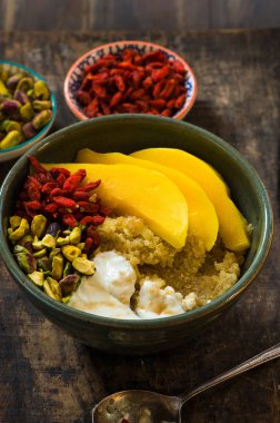 Mango, Antep fıstığı, goji meyveleri ve bal yoğurt ile Quinoa yulaf lapası