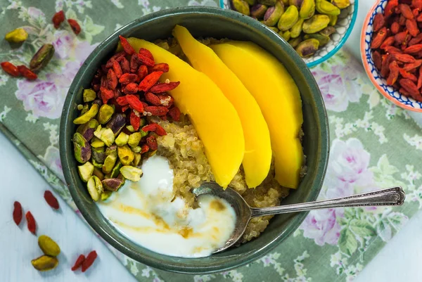 Mango, Antep fıstığı, goji meyveleri ve bal yoğurt ile Quinoa yulaf lapası — Stok fotoğraf