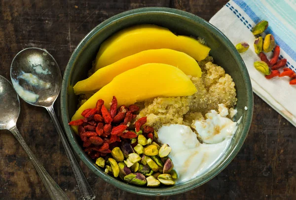 Mango, Antep fıstığı, goji meyveleri ve bal yoğurt ile Quinoa yulaf lapası