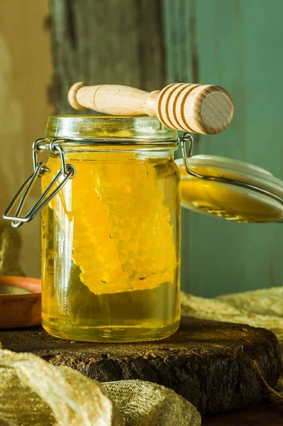 Miel en un frasco con peine de miel dentro —  Fotos de Stock