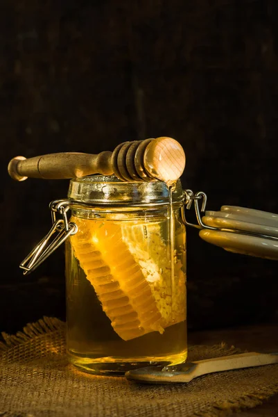 Miel en un frasco con peine de miel dentro —  Fotos de Stock