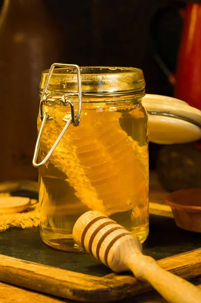 Miel en un frasco con peine de miel dentro —  Fotos de Stock