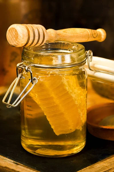 Miel en un frasco con peine de miel dentro —  Fotos de Stock