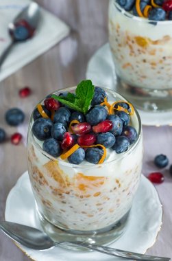 Friesh meyve ile süslenmiş turuncu ve böğürtlenli yoğurt püresi