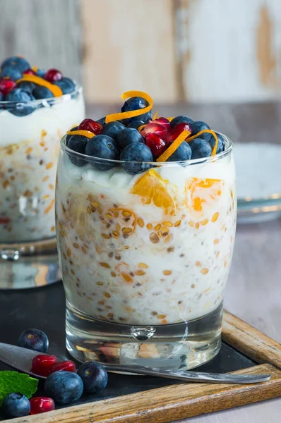 Orange and blueberry yoghurt porridge garnished with friesh fruit — Stock Photo, Image