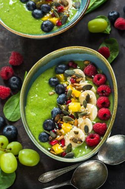 Yeşil avokado, ıspanak ve üzüm güler yüzlü taze meyve ile süslenmiş.