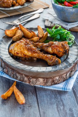 Zencefilli bira soslu tavuk budu patates dilimleri ve tabakta salata.