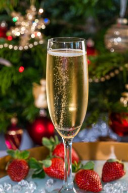Şenlikli arka planda çilekli, kadehli şampanya.