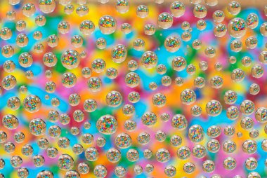 Camın üzerindeki su damlacıklarından yansıyan renkli kanama - desenli arkaplan