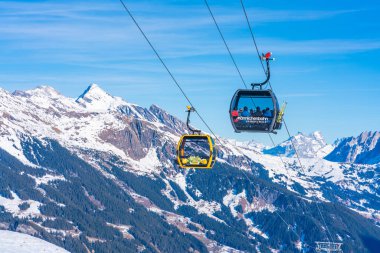 Grindelwald, İsviçre - 12 Ocak 2020: Mannlichenbahn Cablecar 'daki kayakçılar, Jungfrau Bölgesi' nin popüler bir kayak merkezindeki Mannlichen dağının zirvesine çıkarlar.