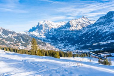 Grindelwald, İsviçre - 12 Ocak 2020: Mannlichen dağındaki Alpler karla kaplı Grindelwald manzarası. Ünlü zirveler arasında Eiger, Monch ve Jungfrau yer alıyor.