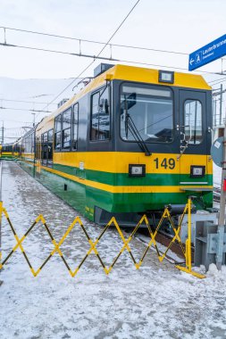 Grindelwald, İsviçre - 13 Ocak 2020: Grindelwald Grund üzerinden Kleine Scheidegg 'e giden Wengernalpbahn' ın yeşil ve sarı treni Grindelwald tren istasyonuna varır.. 