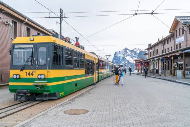 Grindelwald, İsviçre - 13 Ocak 2020: Grindelwald Grund üzerinden Kleine Scheidegg 'e giden Wengernalpbahn' ın yeşil ve sarı treni Grindelwald tren istasyonuna varır..