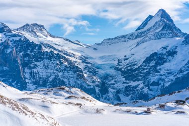 İsviçre 'nin Grindelwald kayak merkezindeki İsviçre Alpleri' nin ilk dağından görülen karla kaplı tepeleriyle kış manzarası