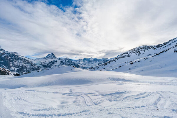 Winter landscape with snow covered peaks seen from the First mountain in Swiss Alps in Grindelwald ski resort, Switzerland