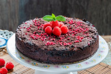 Çikolata ve ahududu turtası. Taze meyve ve nane ile süslenmiş.