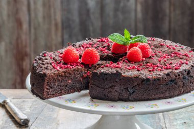 Çikolata ve ahududu turtası. Taze meyve ve nane ile süslenmiş.