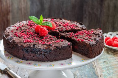 Çikolata ve ahududu turtası. Taze meyve ve nane ile süslenmiş.