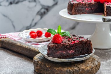 Çikolata ve ahududu turtası. Taze meyve ve nane ile süslenmiş.