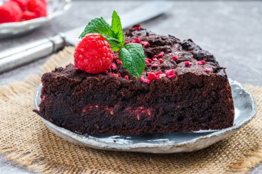 Çikolata ve ahududu turtası. Taze meyve ve nane ile süslenmiş.