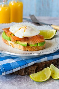 Haşlanmış yumurta, somon balığı ve avokado açık sandviç.