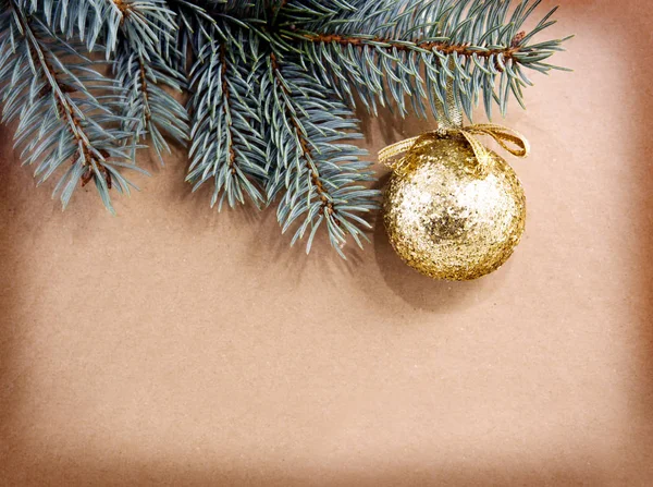 Goldene Weihnachtskugel auf grünem Fichtenzweig isoliert . — Stockfoto