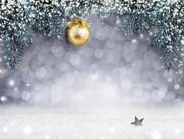 Christmas background with snow and golden ball on spruce branch.