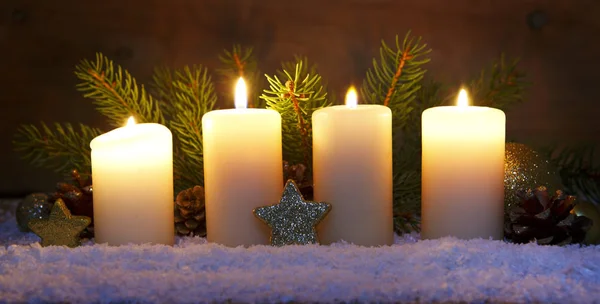 Cuatro velas de adviento ardientes y decoración navideña . — Foto de Stock