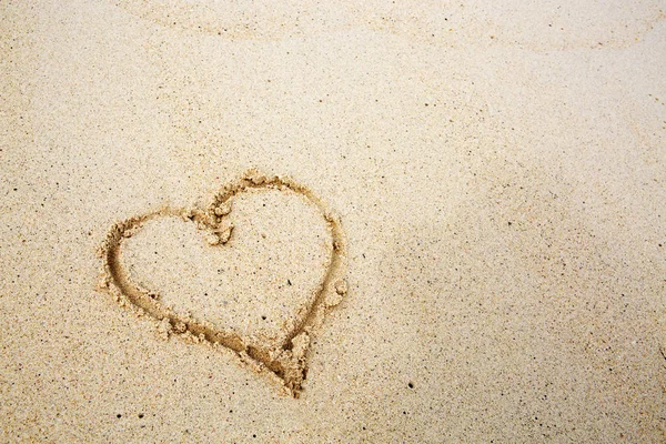 Herzen auf dem Sand eines Strandes gezeichnet. — Stockfoto