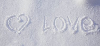 Karda yazılı kalp şekli ve sevgi sözcüğü.