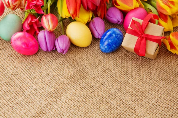 Tulipani primaverili con uova di Pasqua colorate e confezione regalo . — Foto Stock