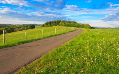 Alan bulutlar ve güneş ile yolda.