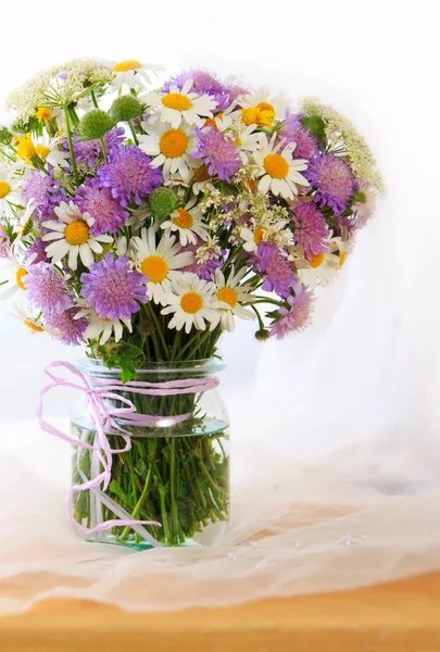 Chamomiles bouquett i vas på tyg bakgrund. — Stockfoto