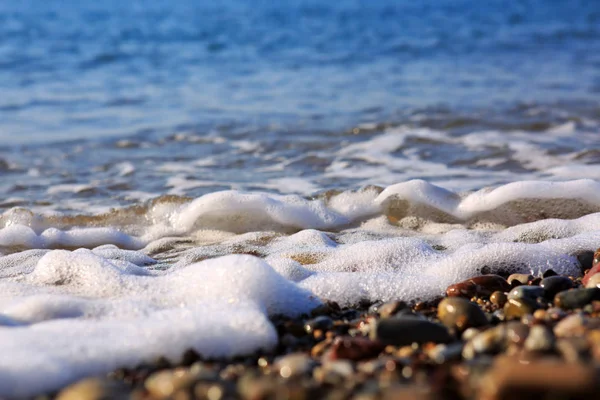 Ondas de lavagem sobre a praia de cascalho, macro tiro. — Fotografia de Stock