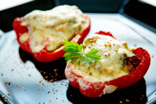 Gevulde rode paprika met paddestoelen op de zwarte plaat. — Stockfoto