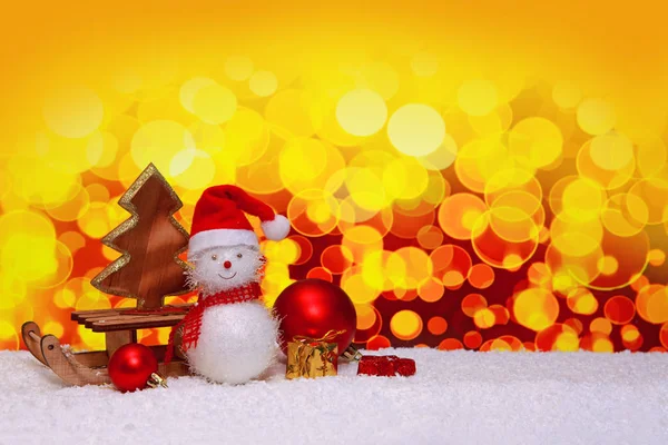 Kardan adam arka plan üzerinde izole kızak üzerinde Noel hediyeleri ile. — Stok fotoğraf