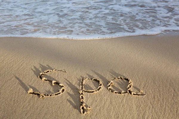Word Spa написано на песке возле моря. Концепция отпуска . — стоковое фото
