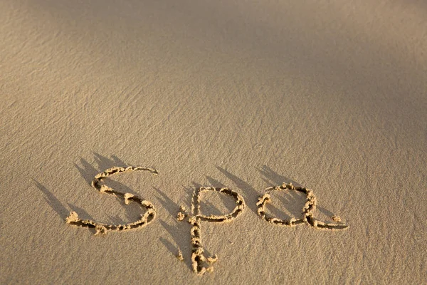 Word Spa написано на песке возле моря. Концепция отпуска . — стоковое фото