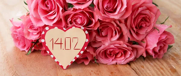 Valentijnsdag achtergrond met roze rozen op de houten tafel. — Stockfoto