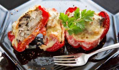 Siyah plaka üzerinde mantar dolması kırmızı biber.