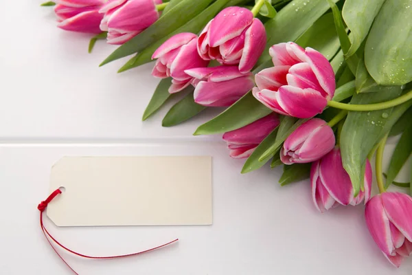 Moederdag kaart en een boeket van mooie tulpen op houten achtergrond. — Stockfoto