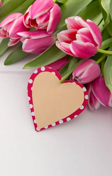 Tarjeta del Día de las Madres y un ramo de hermosos tulipanes sobre fondo de madera . — Foto de Stock