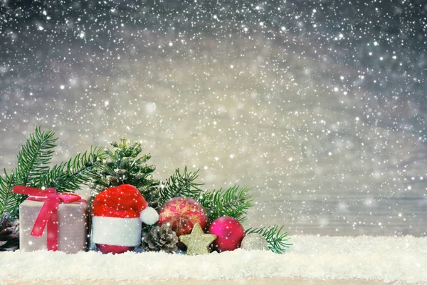 Шляпа Санта-Клауса и подарочная коробка на снегу . — стоковое фото